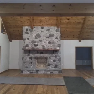 Main-floor stone fireplace with exposed beams in Elverson, PA