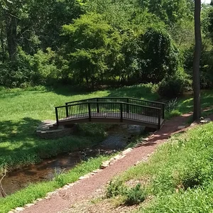 Raised composite bridge set into the landscape along the mulch path in Malvern, PA