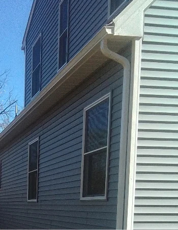 Professional Amish Gutter Services installing new seamless aluminum gutters on a home