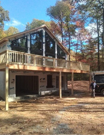 Finished composite deck with black metal railings overlooking wooded yard in Compass, PA