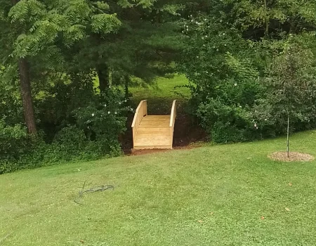 A recently hardscaped yard with a wooden bridge in Chester County, PA