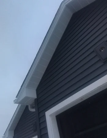 Dark board-and-batten siding with white gutter system in Downingtown, PA