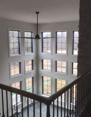 A large, two-story grid of windows dominates the wall of a contemporary open space